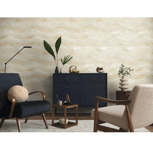 Moderne woonkamer met behang met abstract patroon in beige en goud, donkerblauw dressoir en twee fauteuils.