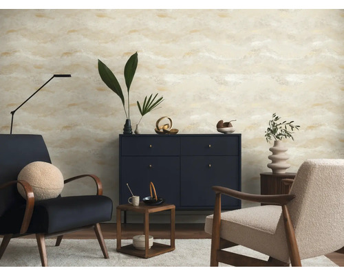Moderne woonkamer met behang met abstract patroon in beige en goud, donkerblauw dressoir en twee fauteuils.