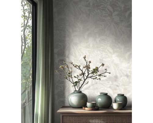 Vliesbehang met subtiel bladerpatroon in een lichte, natuurlijk ingerichte kamer met houten dressoir en keramieken vazen.