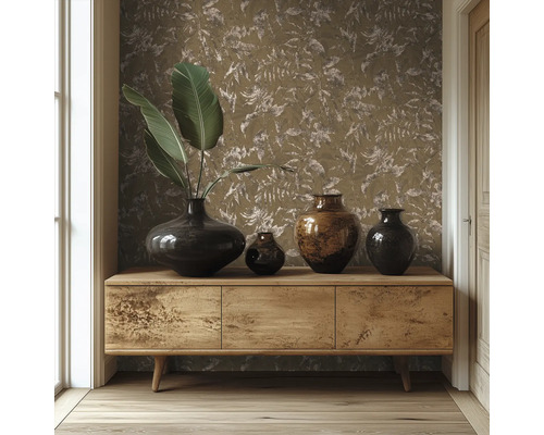 Houten dressoir voor een muur met behang met bladmotief, gedecoreerd met verschillende donkere vazen en grote groene bladeren.