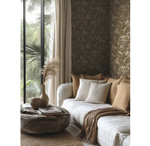 Vliesbehang met floraal patroon in aardetinten achter een bank met kussens en een rustieke boomstamtafel.