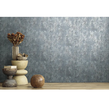 Vliesbehang met gestructureerde betonlook en metaaleffect in een modern ingerichte kamer met houten vloer.