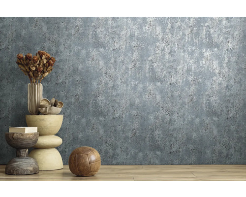 Vliesbehang met gestructureerde betonlook en metaaleffect in een modern ingerichte kamer met houten vloer.