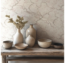 Behang met fijn takken- en bloesempatroon achter een compositie van keramieken vazen en schalen op een rustieke houten bank.