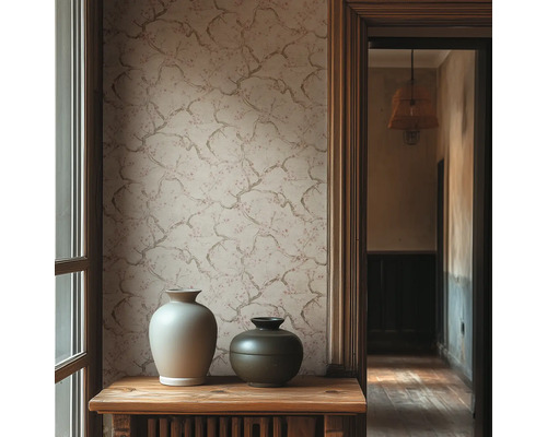 Vliesbehang met verfijnd takkenpatroon op een muur achter twee decoratieve keramieken vazen op een houten tafel in een lichte kamer.