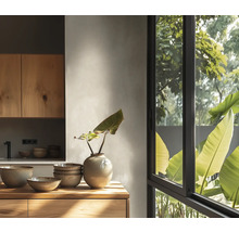 Moderne lichte keuken met houten kasten, keramische schalen op een houten aanrecht en een groot raam met uitzicht op groen.