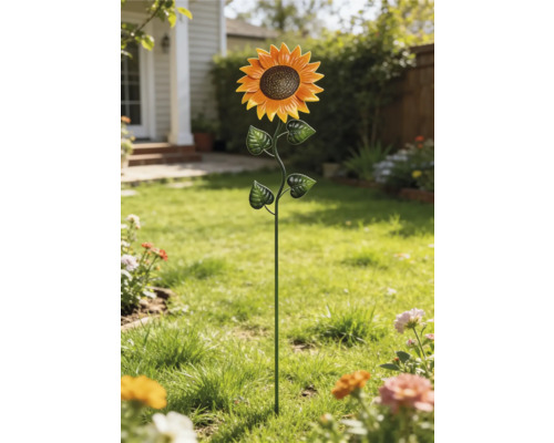 Decoratieve tuinsteker in de vorm van een zonnebloem van metaal op een gazon.