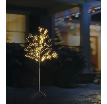 Verlichte LED-decoratieboom voor buiten met vele kleine lichtpuntjes in een nachtelijke tuin voor een huis.