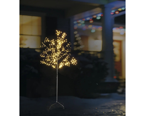 Verlichte LED-decoratieboom voor buiten met vele kleine lichtpuntjes in een nachtelijke tuin voor een huis.