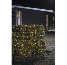 Warmwitte LED-lichtketting voor buiten, gewikkeld om een haag, bij nacht in een tuin voor een huis.