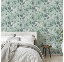 Moderne, lichte slaapkamer met vliesbehang met bloemenpatroon in aquarellook, een bed en een houten bijzettafel.