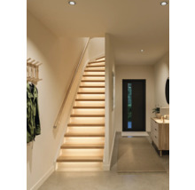 Moderne houten trap met geïntegreerde ledverlichting in een lichte, georganiseerde hal met kapstok en dressoir.