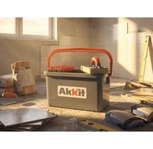 AkKit tegelschoonmaakset met emmer, rollen en sponsspaan op een bouwplaats met tegels, lijm en gereedschap.