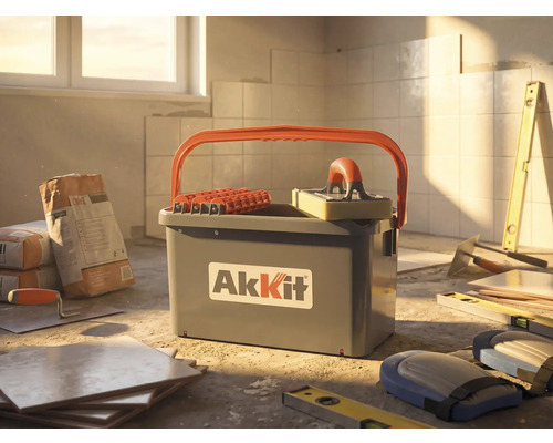 AkKit tegelschoonmaakset met emmer, rollen en sponsspaan op een bouwplaats met tegels, lijm en gereedschap.