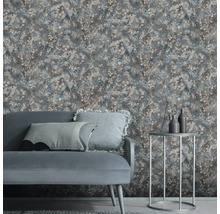 Vliesbehang met bloemmotief in een moderne woonkamer met grijze bank en een ronde bijzettafel.