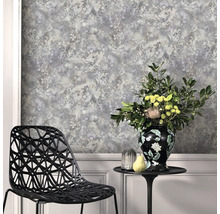 Vliesbehang met bloemenpatroon in aquarellook, moderne zwarte designstoel en bijzettafel met bloemenvaas voor een wand met lambrisering.