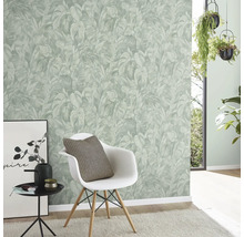Moderne lichte kamer met vliesbehang met junglepatroon van palmbladeren, witte stoel en hangende kamerplanten.