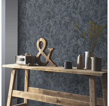 Vliesbehang met tropisch bladmotief achter een houten consoletafel met een ampersand en verschillende vazen.