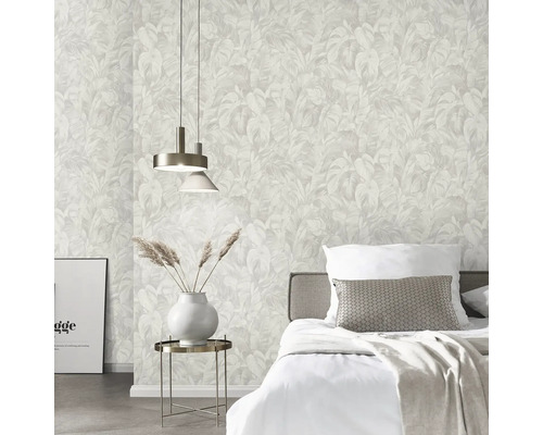 Lichte slaapkamer met vliesbehang met tropisch bladpatroon, bed met wit beddengoed en bijzettafel met vaas.