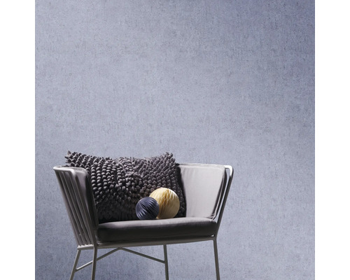 Structuurbehang achter een moderne fauteuil met een getextureerd kussen en decoratieve elementen.