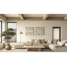 Lichte, modern ingerichte woonkamer met beige hoekbank, houten tafel, twee abstracte kunstwerken, vloerlamp en kamerplant onder houten plafondbalken.