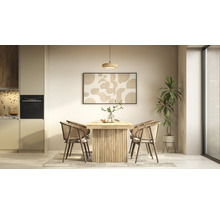Helder ingerichte, georganiseerde eethoek met houten tafel, rotan stoelen, hanglamp en abstracte wandkunst naast een moderne keuken.