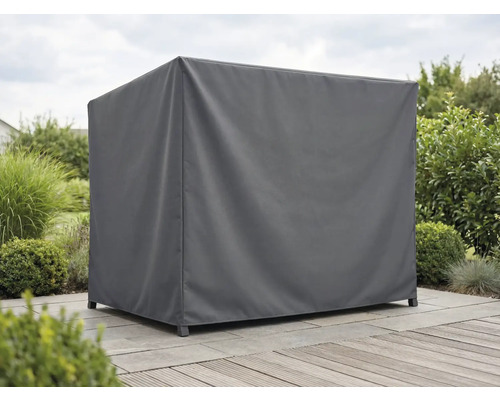 Weerbestendige textiele beschermhoes voor tuinmeubelen op een licht, verzorgd terras met houten vlonder en stenen tegels in een tuin.