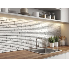 Keuken met een achterwand van witte mozaïektegels in baksteenlook met marmerstructuur, houten werkblad, roestvrijstalen spoelbak en ledverlichting.