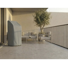 Licht, modern terras met een grijze beschermhoes voor tuinmeubelen, loungeset van metaal en een olijfboom in pot.