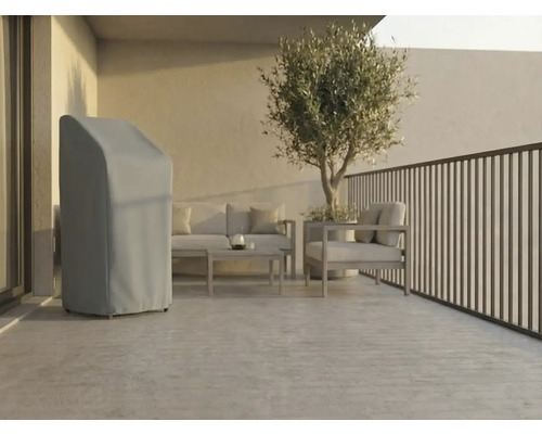 Licht, modern terras met een grijze beschermhoes voor tuinmeubelen, loungeset van metaal en een olijfboom in pot.