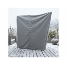 Grijze beschermhoes voor een strandstoel op een besneeuwd houten terras in de tuin.