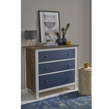 Commode met drie blauwe laden, wit frame en houten bovenblad in een modern ingerichte kamer.