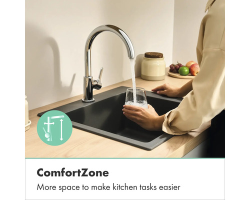 Keukenkraan in chroom met hoge uitloop, water stroomt in een glas in een donkere gootsteen, toont meer bewegingsvrijheid door ComfortZone.