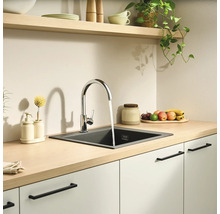 Moderne, lichte keuken met een houten werkblad, een verchroomde mengkraan en een donkere inbouwspoelbak van composiet.