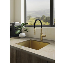 Lichte moderne keuken met gouden onderbouwspoelbak en mengkraan met zwarte slang op een aanrechtblad met marmerlook.