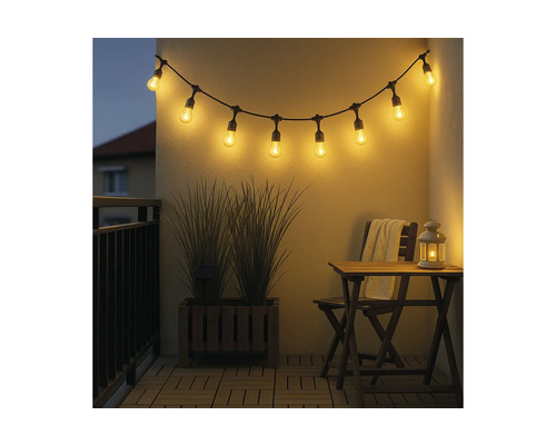 Lichtsnoer met led-lampen op een balkon met houten meubels en plantenbak in de avond.