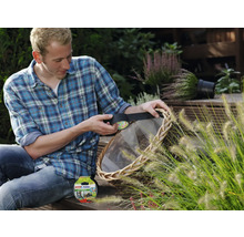 Man repareert een rieten mand met zwarte tesa Extra Power Eco Repair tape in een tuin.