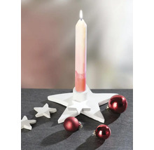 Kerstdecoratie met een witte stervormige kandelaar, een brandende kaars, kleine decoratieve sterren en rode kerstballen.