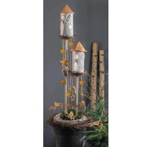 Decoratieve torens met verlichte ramen, hangende sterren en dennenappels in een rustieke nestbasis met groen en vogels.