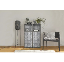 Moderne woonkamer met grijze kast met tegelpatroon, hoge zwarte lantaarn en donkere stoel met pluizig kussen.