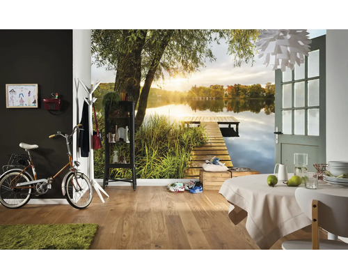 Fotobehang met meer, houten steiger en zonsondergang in een modern ingerichte kamer met houten vloer en eettafel.