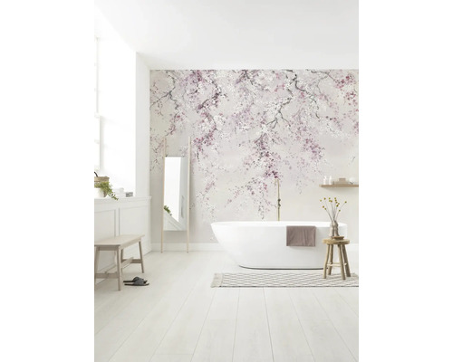 Lichte, moderne badkamer met kersenbloesem fotobehang, een vrijstaand wit ligbad en houten meubels.