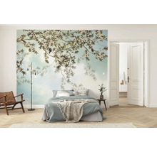 Lichte slaapkamer met fotobehang van bloeiende takken en vogels, bed, houten loungestoel met leer en visgraatvloer.