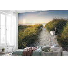 Fotobehang in een slaapkamer met strandmotief, duinen en zonsondergang boven de zee.