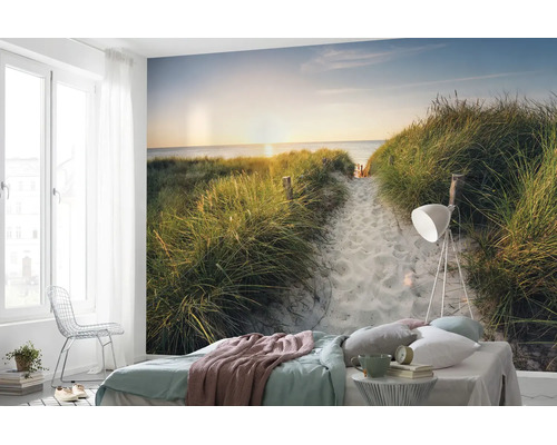 Fotobehang in een slaapkamer met strandmotief, duinen en zonsondergang boven de zee.