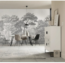 Lichte eetkamer met fotobehang met bosmotief, een moderne eettafel met diverse stoelen en een kast.