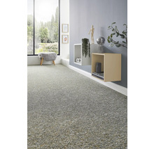 Grijs tapijt met textuur in een moderne woonkamer met zwevende planken en een groot raam met uitzicht op de tuin.