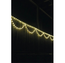 LED-lichtsnoer warmwit aan een houten schutting buiten in de nacht.