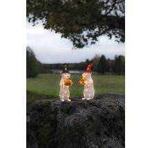Twee verlichte muisfiguren van acryl met hoeden, pompoen en kaas op een bemoste rots in de buitenlucht.