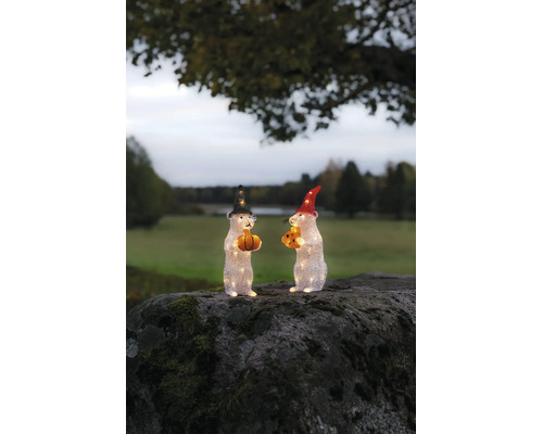 Twee verlichte muisfiguren van acryl met hoeden, pompoen en kaas op een bemoste rots in de buitenlucht.